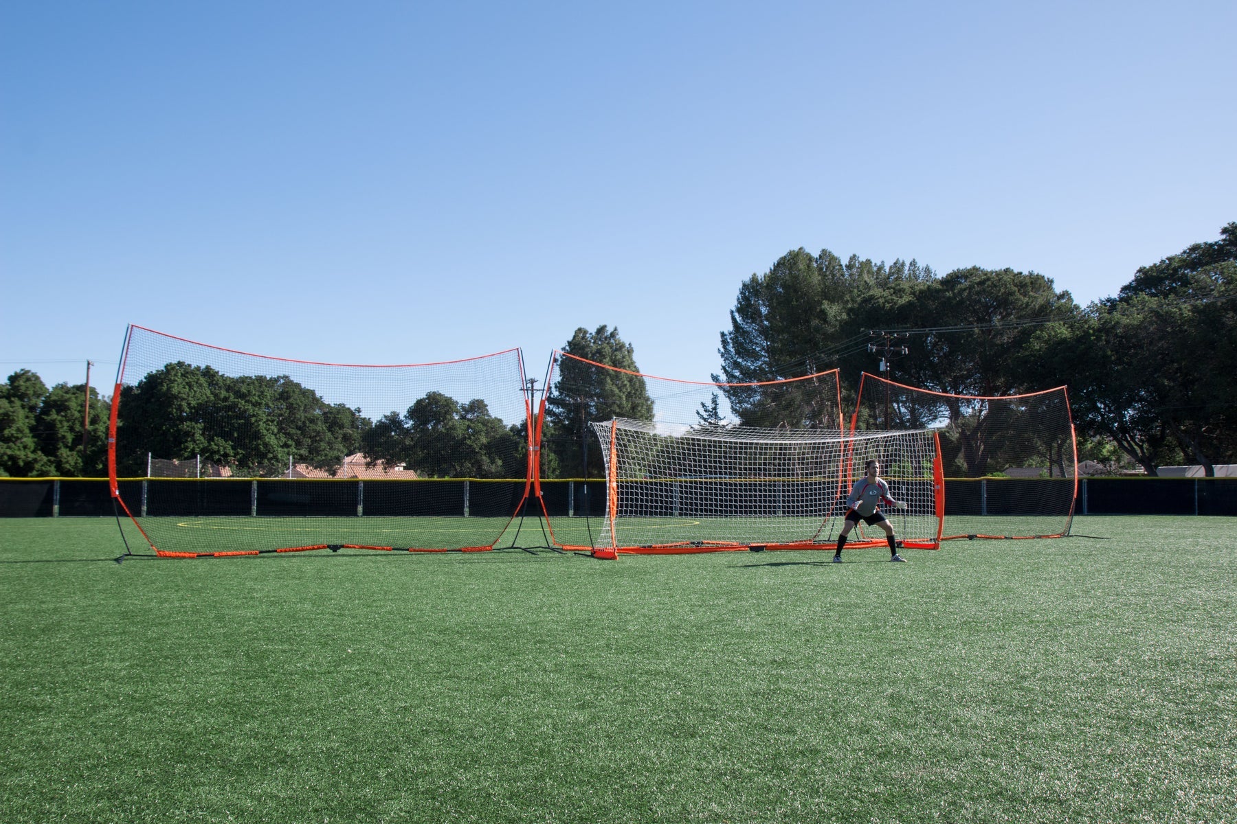 Big barrier net positioned with soccer goal showing space-saving field setup
