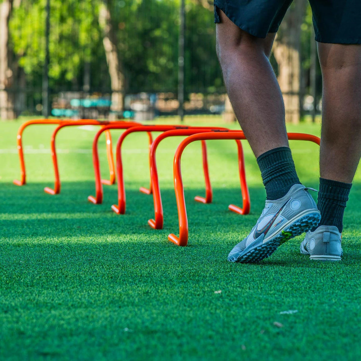 Bright orange 12-inch PVC hurdle with bounce-back construction for soccer training